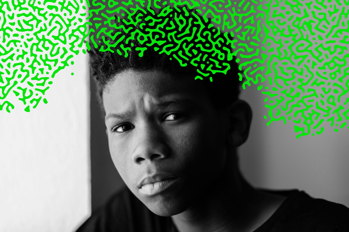 An African American teen boy looking sadly at the viewer with a bright green overlay of an organic brain-like pattern covering the top third of the image